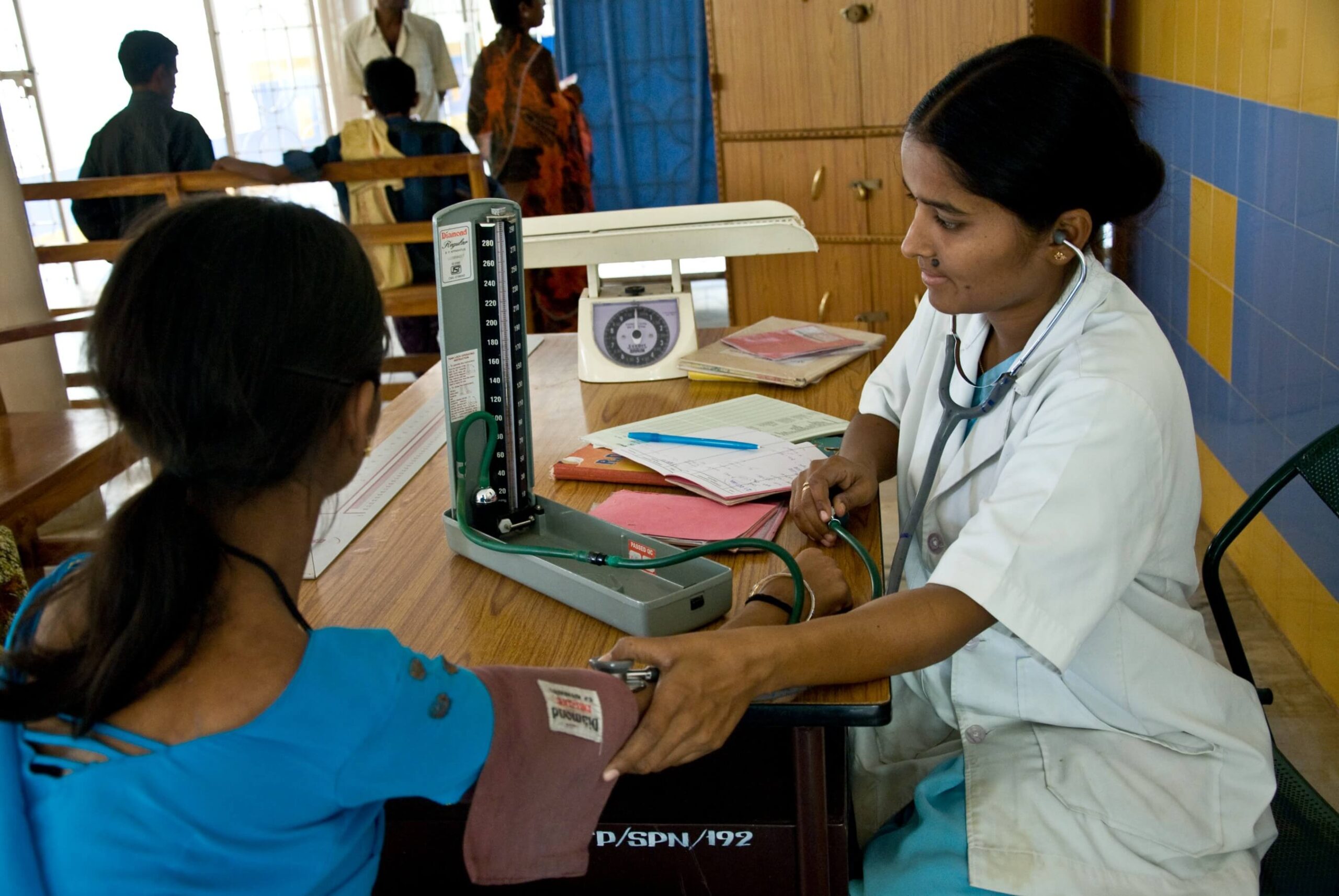 A female doctor from Bathalapalli Department checking a woman's blood pressure.