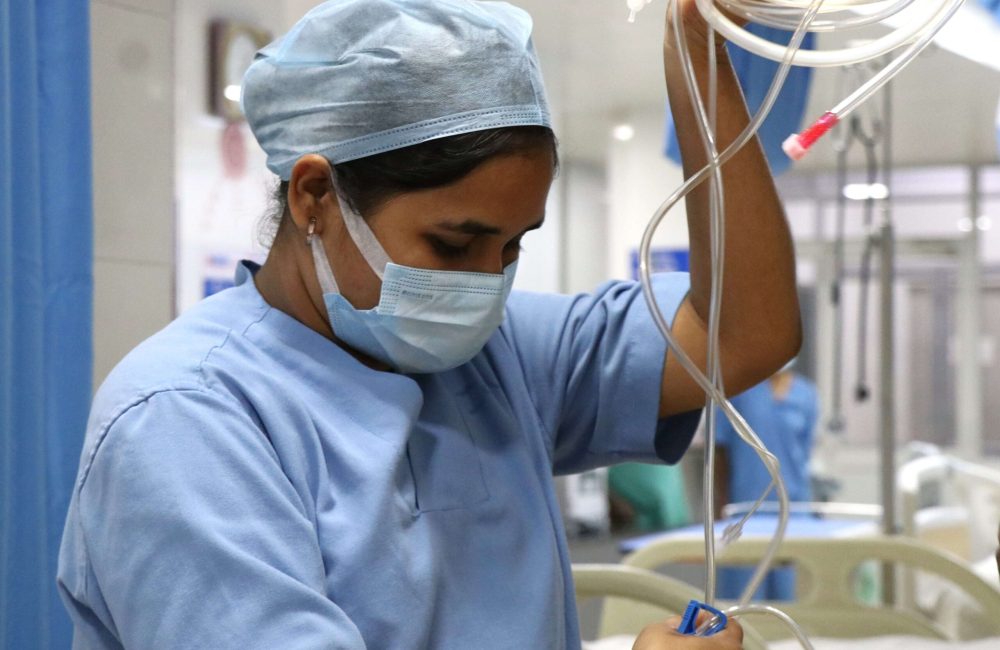 A nurse from the Emergency Medicine Department in Bathalapalli is holding a wire in an operating room.